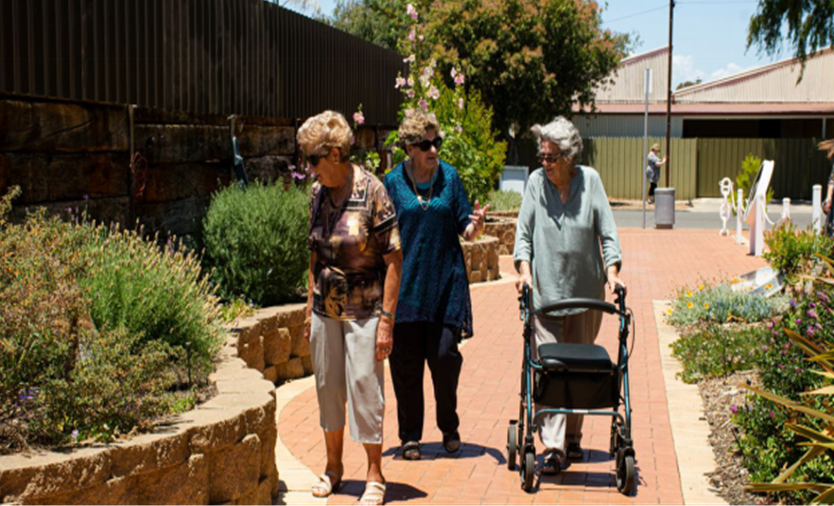 Three senior women strolling and chatting together outdoors